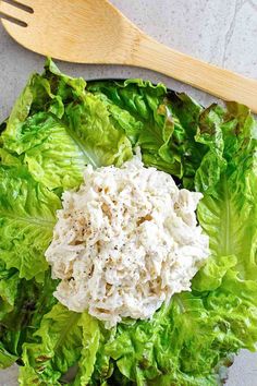 lettuce and cheese salad in a bowl with a wooden fork on the side