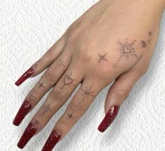 a woman's hand with stars and hearts tattooed on her left ring finger,