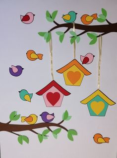 the paper birds are hanging from the tree branch with their own birdhouse on it