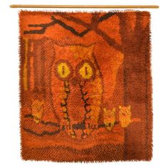 an orange owl rug hanging on a wall