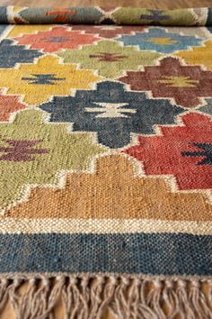 a multicolored rug with fringes on the floor