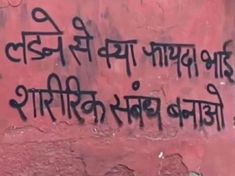 graffiti written on the side of a building in india, with an image of a man's head