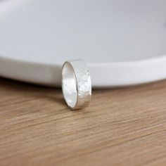 A handmade 925 sterling silver band ring with a hammered finish. An everyday staple.• d e t a i l s •A 925 sterling silver ring approximately 6mm wide.• d e l i v e r y •Your jewellery is handmade to order, and I aim to dispatch within 3-5 working days (please check the shop announcement for any updates in processing times)Your order will be sent via Royal Mail 2nd Class post. If you'd like your order sooner, please select a shipping upgrade at checkout.• c a r e •To keep your jewellery looking Unique Silver Rings, Hammered Silver Ring, Hammered Hoop Earrings, Hammered Ring, Hammered Band, Hammered Rings, Sterling Silver Rings Bands, Circle Earrings Studs, Thumb Ring