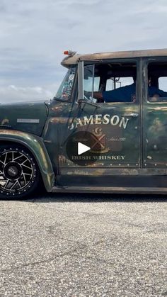 an old green truck parked on top of a parking lot