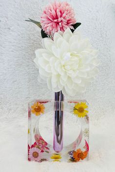 a pink and white flower in a glass vase