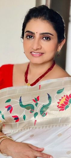 a woman wearing a white sari and red blouse