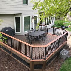 a deck with table and chairs next to a house