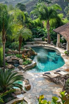 an outdoor swimming pool surrounded by palm trees and other greenery, with a gazebo in the background