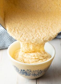 a bowl filled with hummus sitting on top of a wooden table