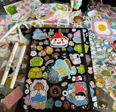 an assortment of stickers and markers on a table