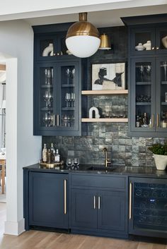 a kitchen with dark blue cabinets and gold accents