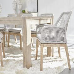 a dining room table and chairs with white rugs