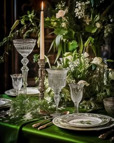 the table is set with glassware and candlesticks for an elegant dinner party