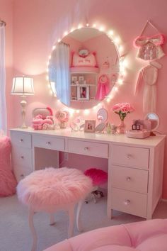 a bedroom with pink furniture and lights on the mirror above it is decorated in white