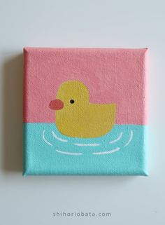 a pink and blue square with a yellow ducky in the water painted on it