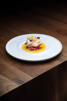 a white plate topped with food on top of a wooden table