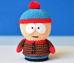 a small crocheted toy with a hat on it's head and eyes