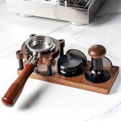 an old fashioned coffee grinder and other kitchen accessories on a marble counter top with a stove in the background