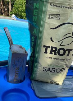 a bag of salt next to a pool with a drink in it and a straw sticking out of it