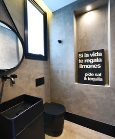 a bathroom with a toilet, sink and large mirror in it's center wall