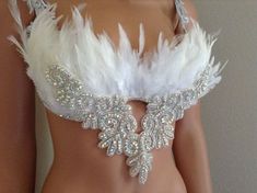 a close up of a person wearing a bra with feathers attached to the chest and back