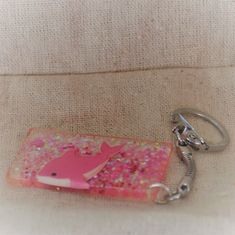 a key chain with a pink whale on it