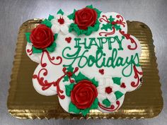 a decorated birthday cake sitting on top of a gold platter with red and white frosting