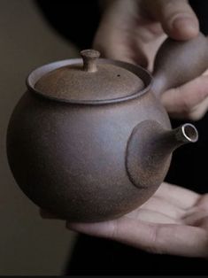 a person holding a teapot in their hands