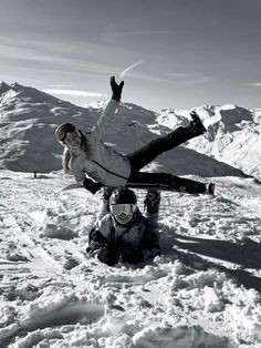 two snowboarders sitting in the snow with their boards on their shoulders and feet