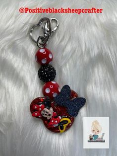 a minnie mouse keychain is on top of a white furnishing surface