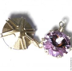 two pendants that have different colored stones on them, one with a cross and the other with a sun