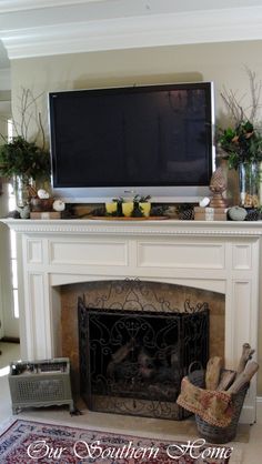 a fireplace with a flat screen tv above it and other decorations on the mantel