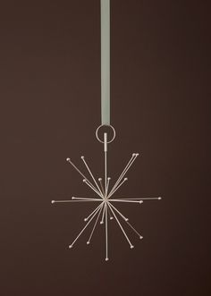 a white snowflake hanging from the ceiling in front of a black wall and floor