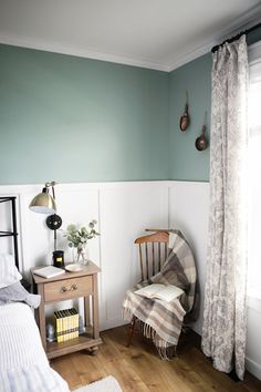 a bedroom with green walls and wooden floors