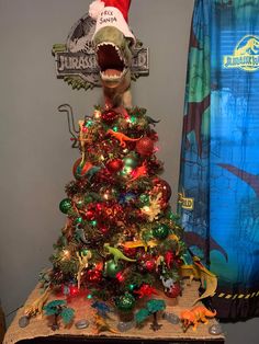 a christmas tree with an alligator head on top and other ornaments around it, in front of a dr seussler sign