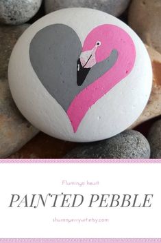 a painted pebble with a pink flamingo heart on it and text overlay