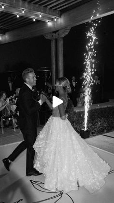 a man and woman dance together in front of fireworks on the dance floor at their wedding reception