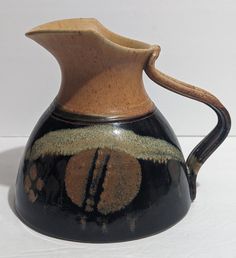 a brown and black vase with designs on it