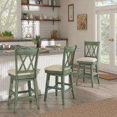 three green chairs sitting in front of a counter top next to an open kitchen door