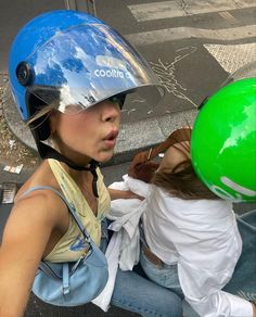 a woman riding on the back of a scooter wearing a helmet