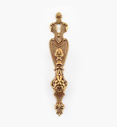 an ornate gold door handle on a white background