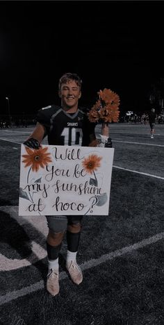 a man holding a sign that says will you be my sunshineflower at once?