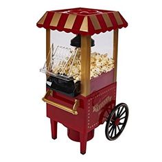 a red and gold popcorn machine on wheels with a canopy over the top for shade