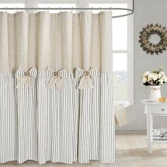 a white and black striped shower curtain next to a window