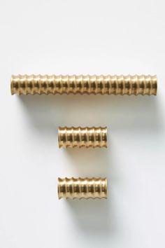 three brass screws on a white background