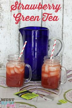 two mugs with strawberries in them sitting on a table