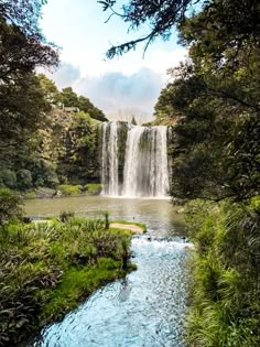 a large waterfall in the middle of a forest