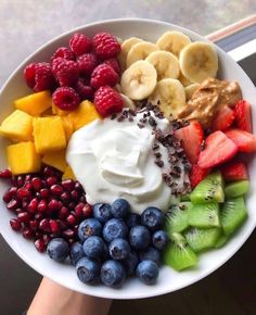 a white bowl filled with fruit and yogurt