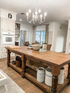 a large wooden table sitting in the middle of a kitchen