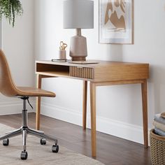 a wooden desk with a lamp on top of it next to a chair and rug